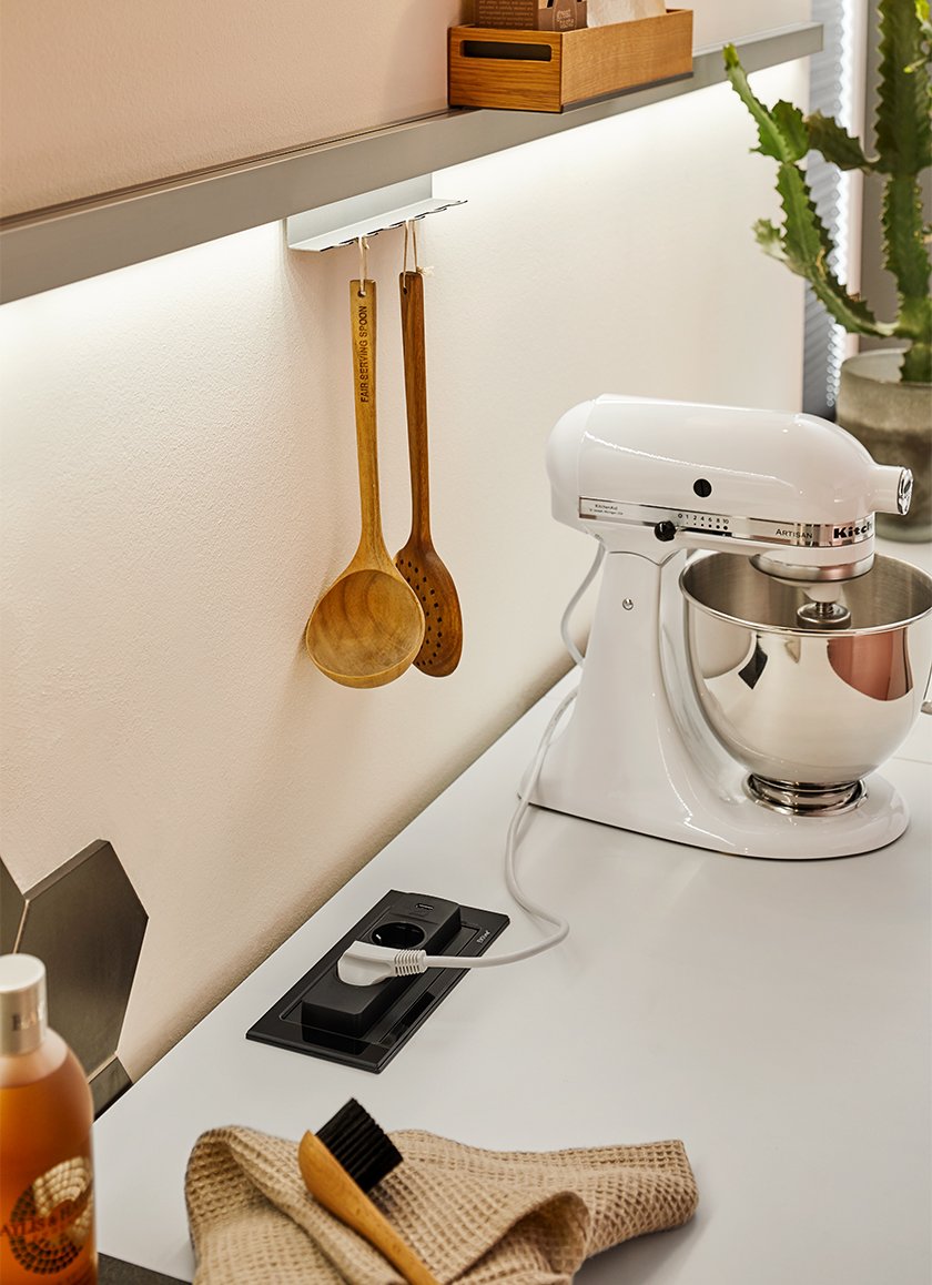 Evoline Backflip installato su top cucina con presa Schuko infilata